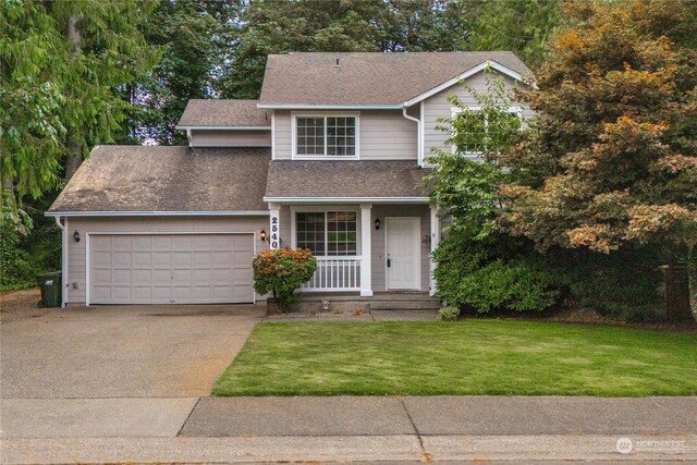 view of front of home with a front yard, a garage, and covered porch