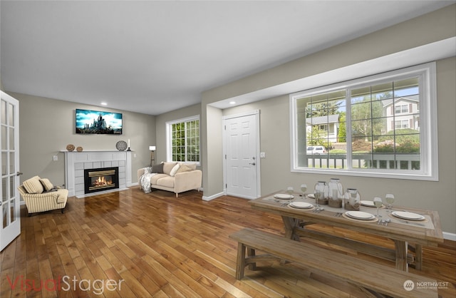 living room featuring wood-type flooring and a tile fireplace