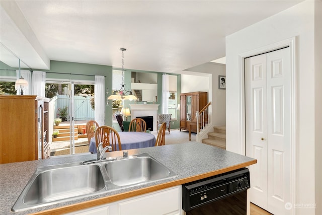 kitchen with light hardwood / wood-style floors, sink, decorative light fixtures, and dishwasher