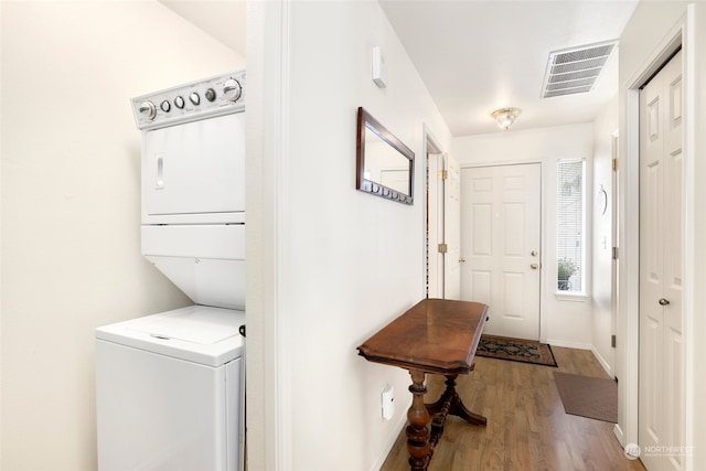 laundry room with stacked washer and dryer and hardwood / wood-style floors