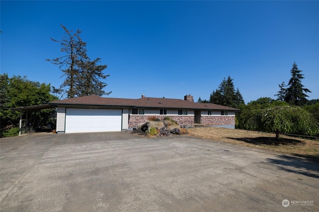 ranch-style home with driveway, a garage, and a chimney