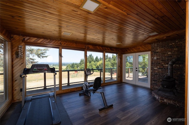 interior space featuring wood walls, a wood stove, french doors, wooden ceiling, and dark wood-type flooring