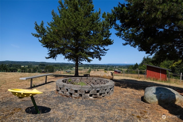 view of yard featuring an outdoor fire pit and fence