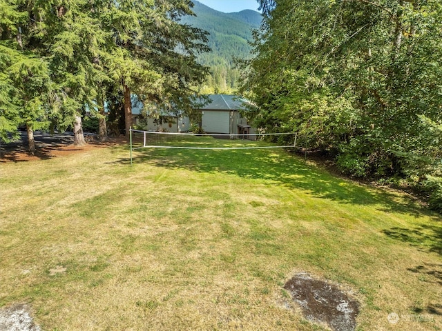 view of yard with a mountain view and volleyball court