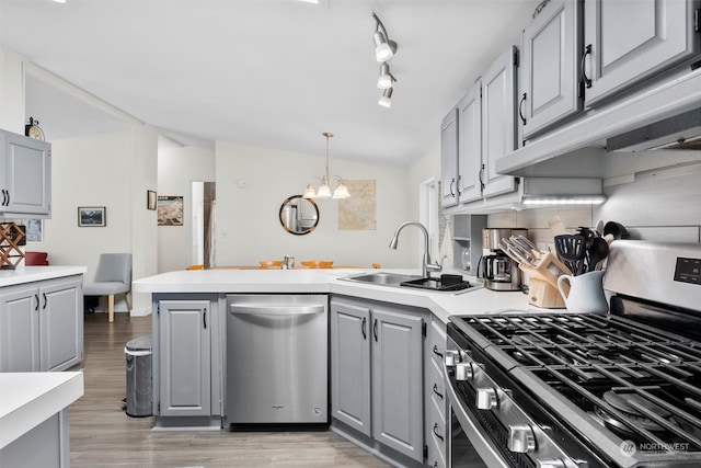 kitchen featuring light hardwood / wood-style floors, appliances with stainless steel finishes, vaulted ceiling, and gray cabinets