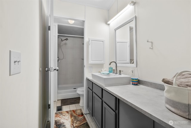 bathroom with tile patterned flooring, a tile shower, vanity, and toilet