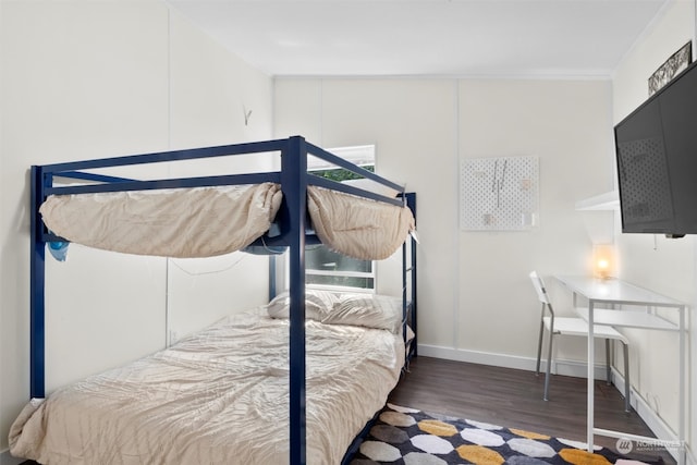 bedroom featuring dark wood-type flooring and crown molding