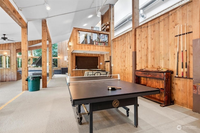 recreation room featuring high vaulted ceiling, wood walls, and ceiling fan