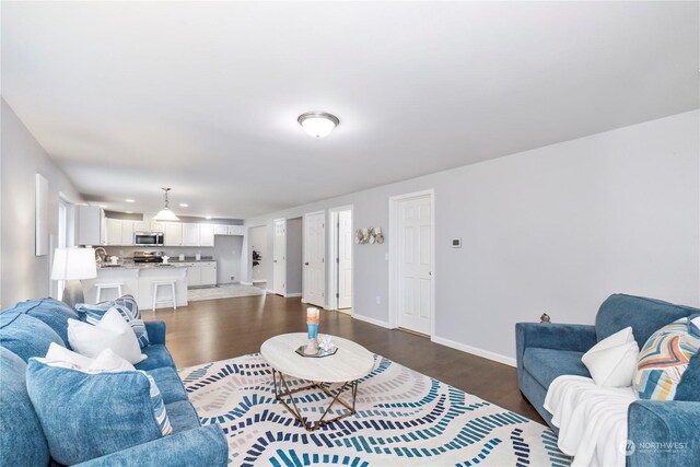 living room featuring dark wood-style flooring and baseboards