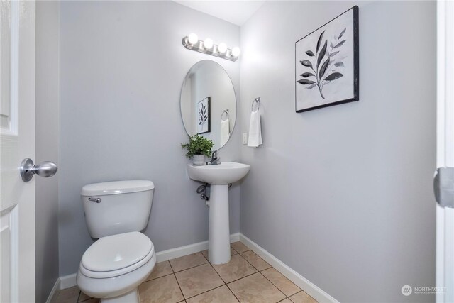 bathroom featuring baseboards, toilet, and tile patterned floors