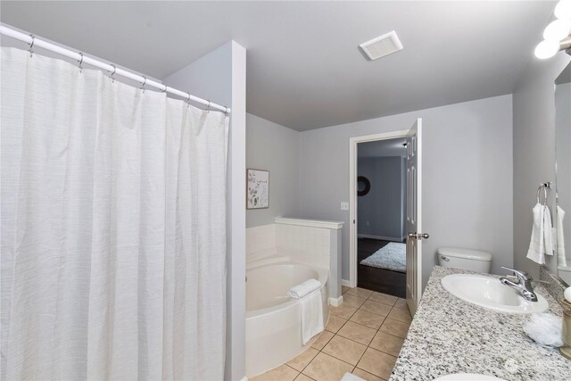 bathroom with tile patterned flooring, visible vents, a garden tub, and vanity