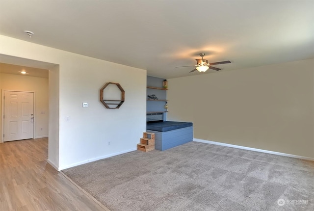 unfurnished living room with light carpet and ceiling fan