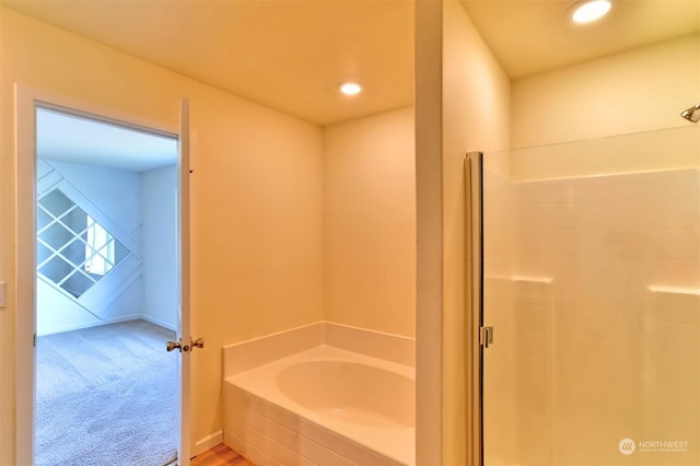 bathroom featuring shower with separate bathtub