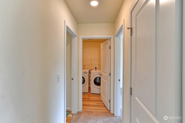 hallway with light colored carpet and washer and clothes dryer