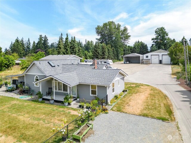 single story home with a front lawn, an outdoor structure, and a garage