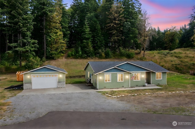 ranch-style home with a garage and an outdoor structure