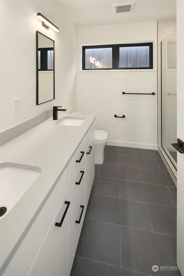 bathroom with an enclosed shower, vanity, tile patterned floors, and toilet