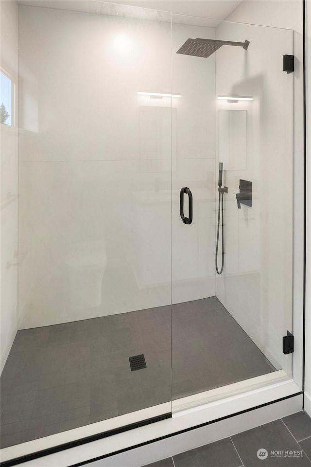 bathroom featuring an enclosed shower and tile patterned flooring