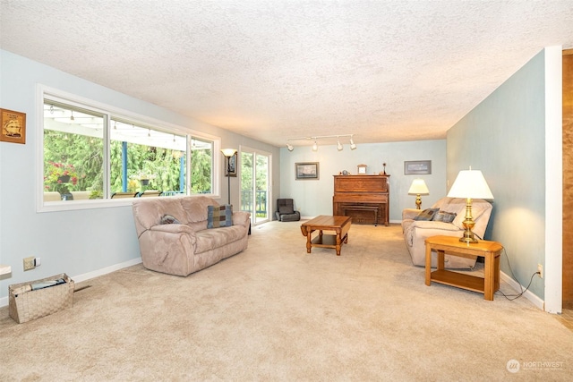 living room featuring carpet floors, baseboards, and a textured ceiling