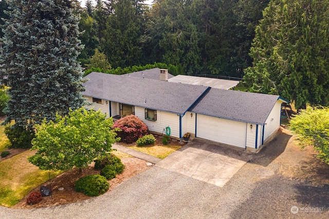 ranch-style house with a garage, a shingled roof, and concrete driveway