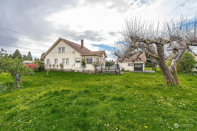 back of house featuring a wooden deck and a lawn