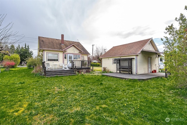 rear view of property featuring a yard and a deck