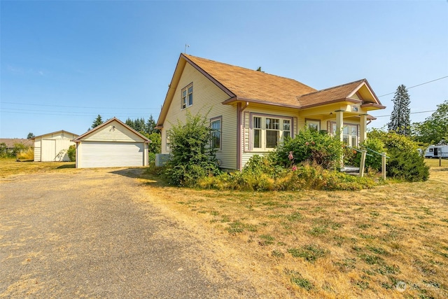 view of front of home with a garage and a storage unit