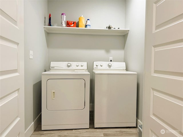 washroom with washer and clothes dryer and light hardwood / wood-style flooring