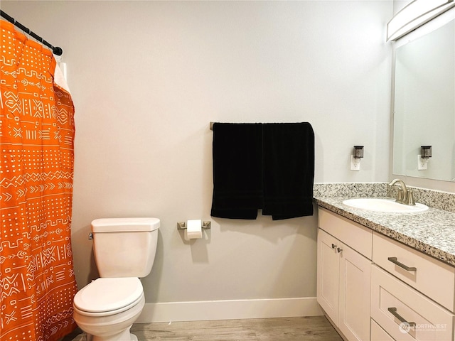 bathroom featuring vanity, hardwood / wood-style floors, and toilet