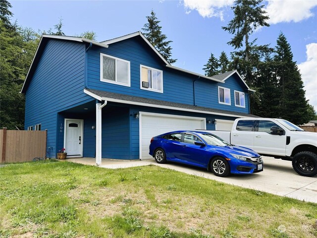 view of front of house featuring a garage and a front lawn