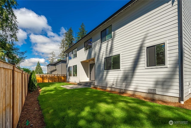 back of property featuring a yard and a patio