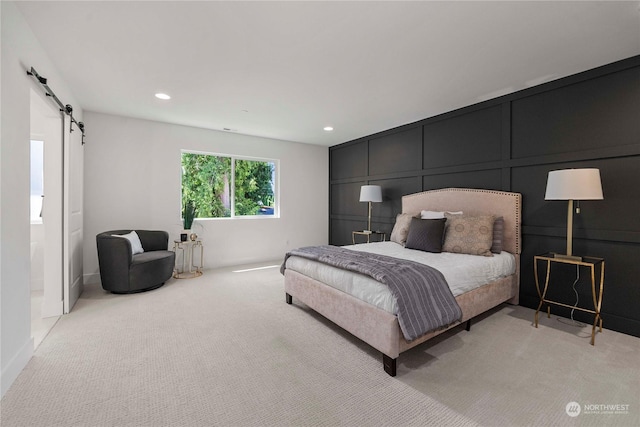 carpeted bedroom featuring a barn door