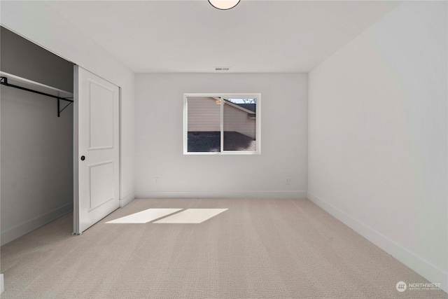 unfurnished bedroom with a closet and light carpet