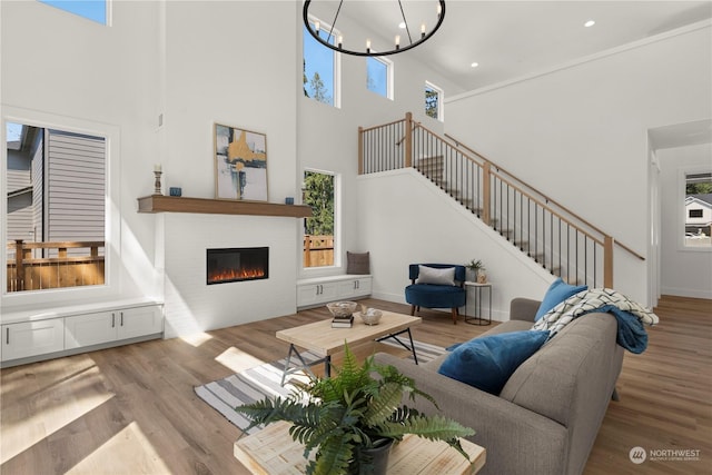 living room featuring a high ceiling, an inviting chandelier, and light wood-type flooring