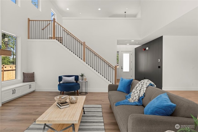 living room featuring a towering ceiling and light hardwood / wood-style floors