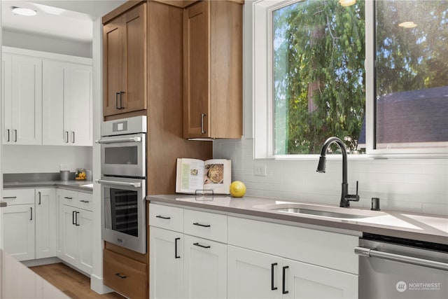 kitchen featuring white cabinetry, stainless steel appliances, sink, and backsplash