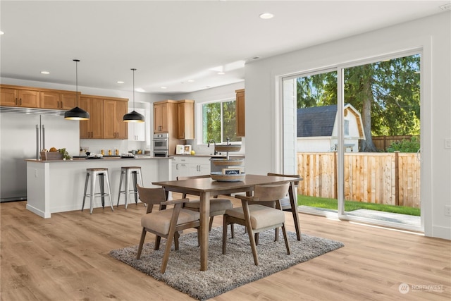 dining space with sink and light hardwood / wood-style floors