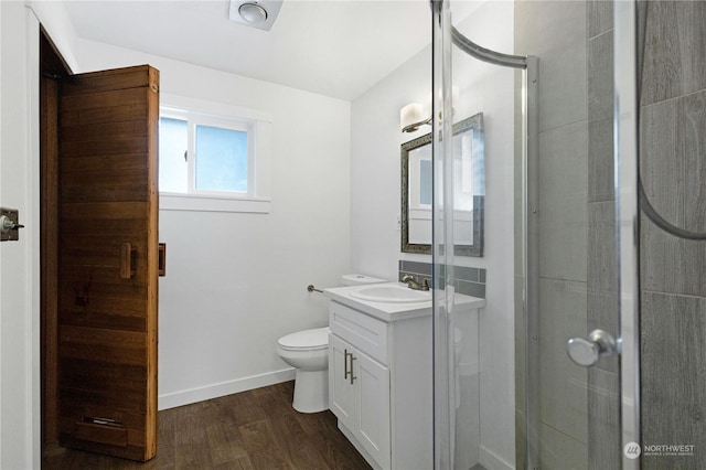 bathroom with a shower with door, vanity, wood-type flooring, and toilet