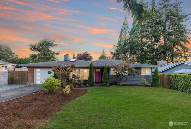 single story home with aphalt driveway, a front yard, fence, and an attached garage