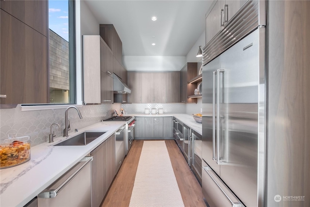 3263 Evergreen Point Rd, Medina, WA 98039 - kitchen with stainless steel appliances, a sink, modern cabinets, light wood-style floors, and tasteful backsplash
