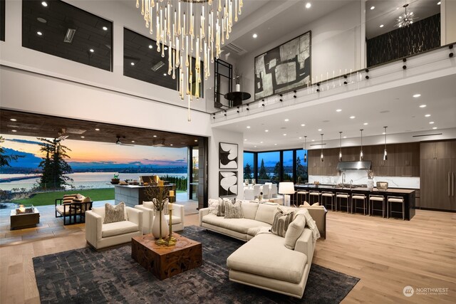 3263 Evergreen Point Rd, Medina, WA 98039 - living room featuring a towering ceiling, light wood-style floors, recessed lighting, and a water view