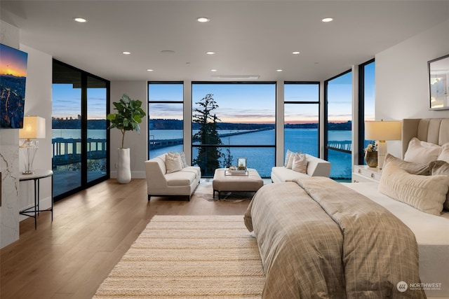 3263 Evergreen Point Rd, Medina, WA 98039 - bedroom with floor to ceiling windows, access to exterior, wood finished floors, recessed lighting, and a water view