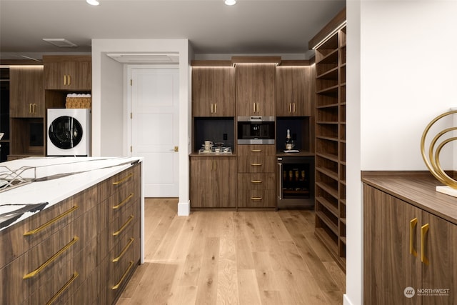 3263 Evergreen Point Rd, Medina, WA 98039 - kitchen featuring wine cooler, open shelves, light wood-style flooring, oven, and stacked washer / drying machine