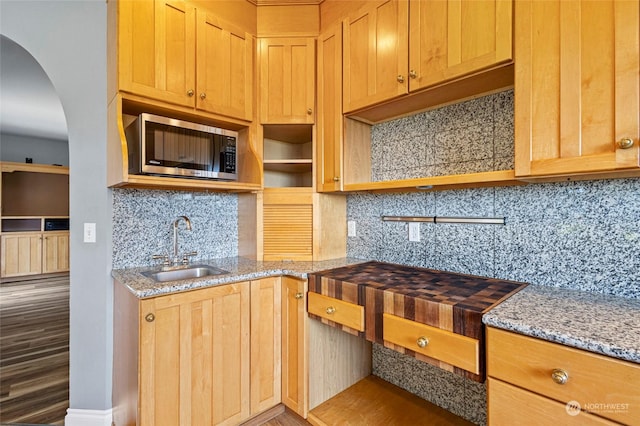 6340 Chuckanut Dr, Bow, WA 98232 - kitchen with stainless steel microwave, open shelves, light stone countertops, arched walkways, and a sink