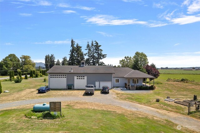 view of front of house featuring a garage, a front lawn, and covered porch