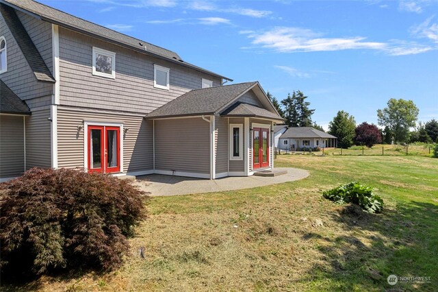 back of property with french doors and a yard