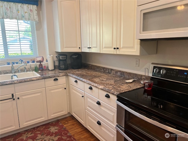 kitchen featuring white cabinetry, double oven range, dark wood-type flooring, and sink