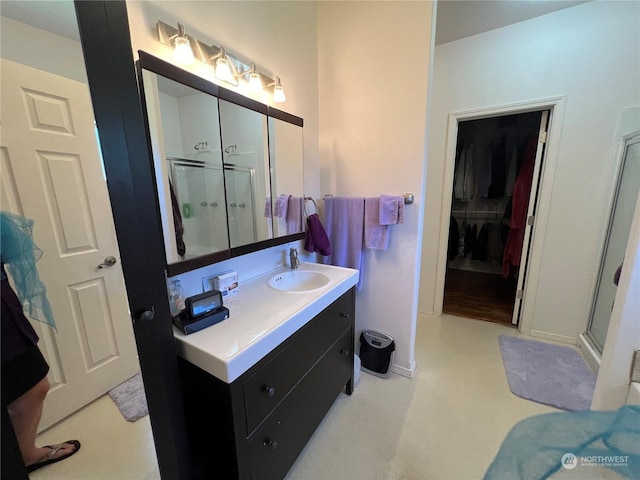 bathroom with a shower with door and vanity