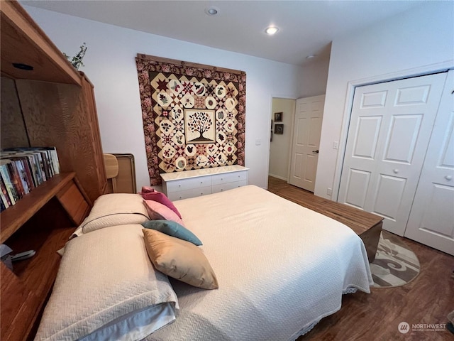 bedroom with dark hardwood / wood-style flooring and a closet