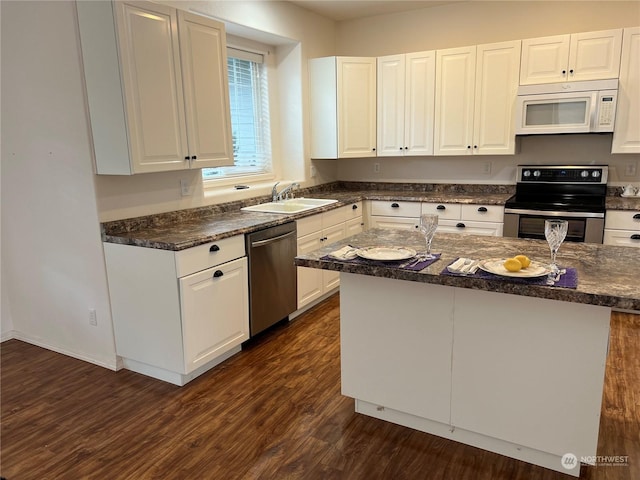 kitchen featuring sink, appliances with stainless steel finishes, white cabinetry, dark hardwood / wood-style floors, and a kitchen island